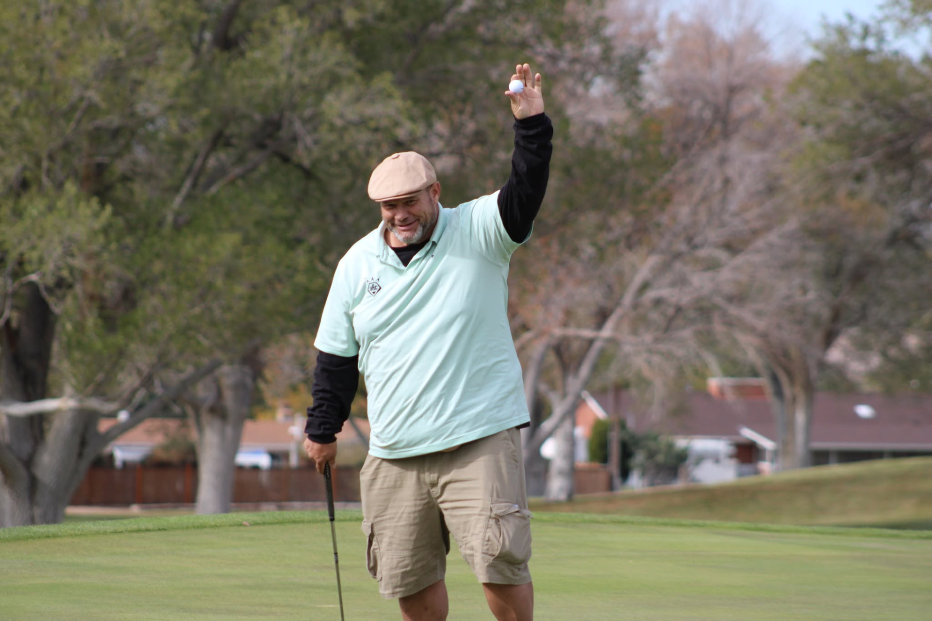 Golfer celebrating with a golf ball raised overhead