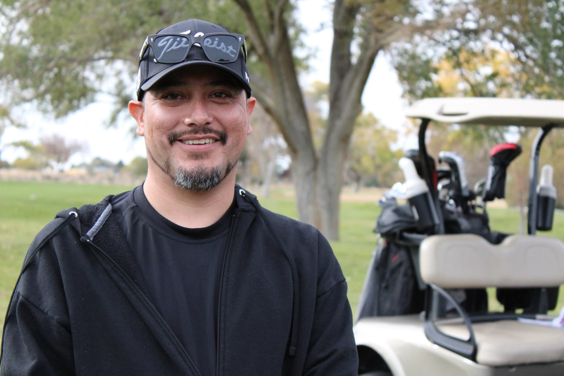 Candid portrait of a golfer beside a golf cart
